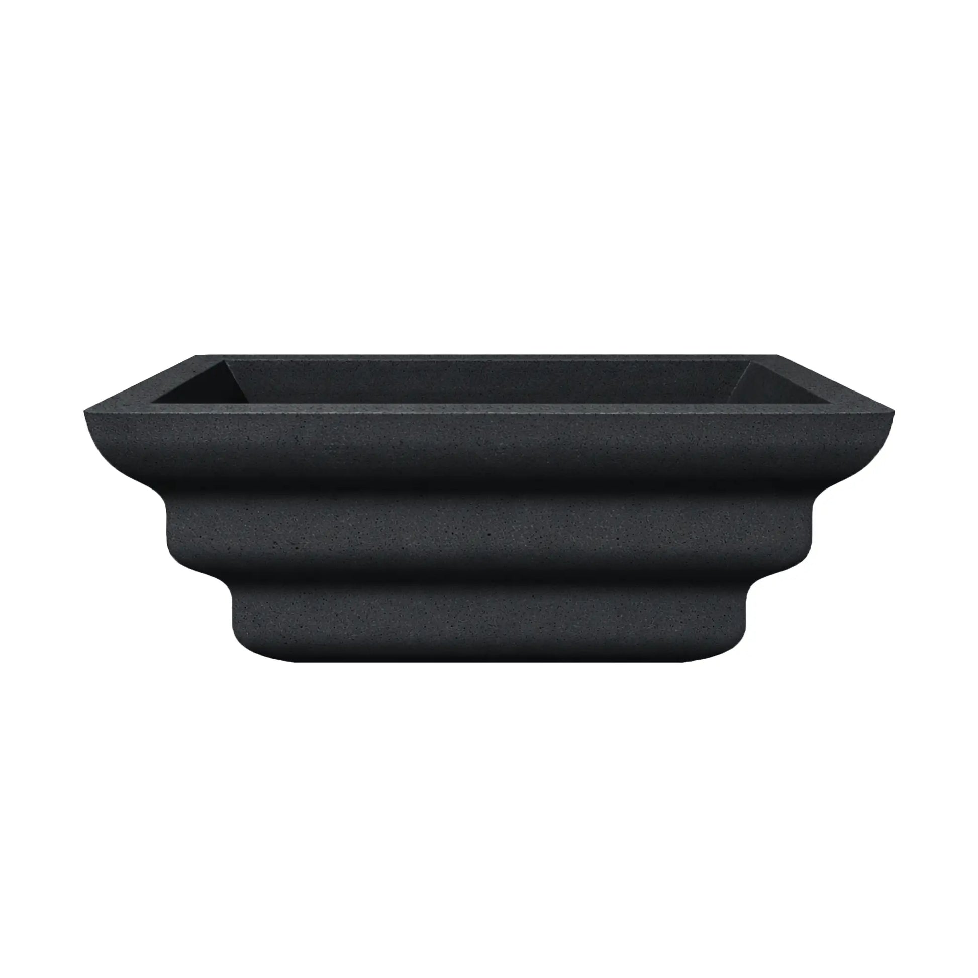 Side profile view of the black Shadow Cast Ripple Designer Series fire bowl with an empty basin. The sculpted ripple-style exterior creates layered curves that give the bowl a distinctive architectural look. The square rim and tapered base highlight the bowl’s modern outdoor fire feature design.