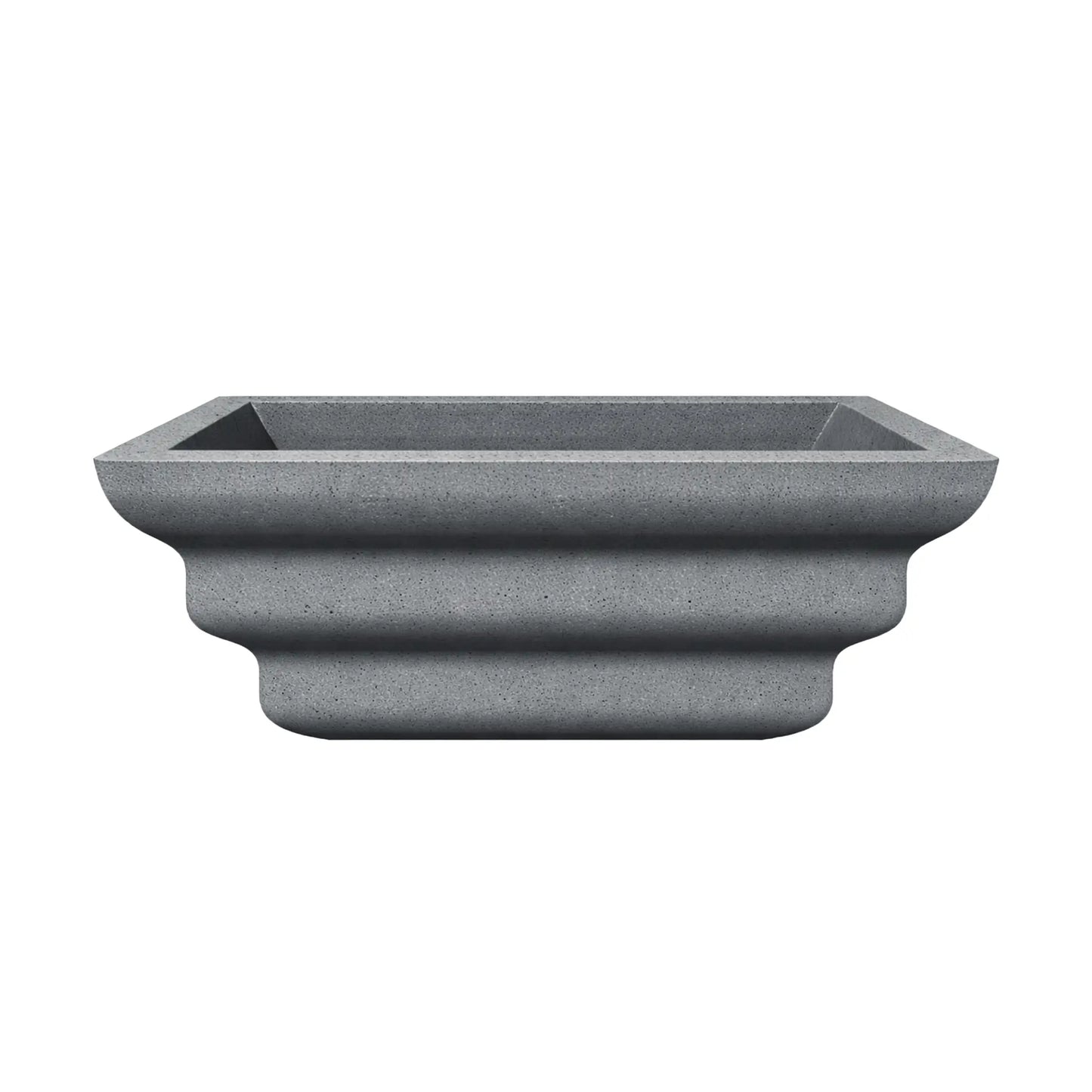 Side profile of the gray Shadow Cast Ripple Designer Series fire bowl with no burner or media installed. The sculpted ripple-style exterior creates three layered curves along the base, giving the bowl a distinctive architectural look. The square top opening and textured gray finish emphasize its modern outdoor fire feature design.