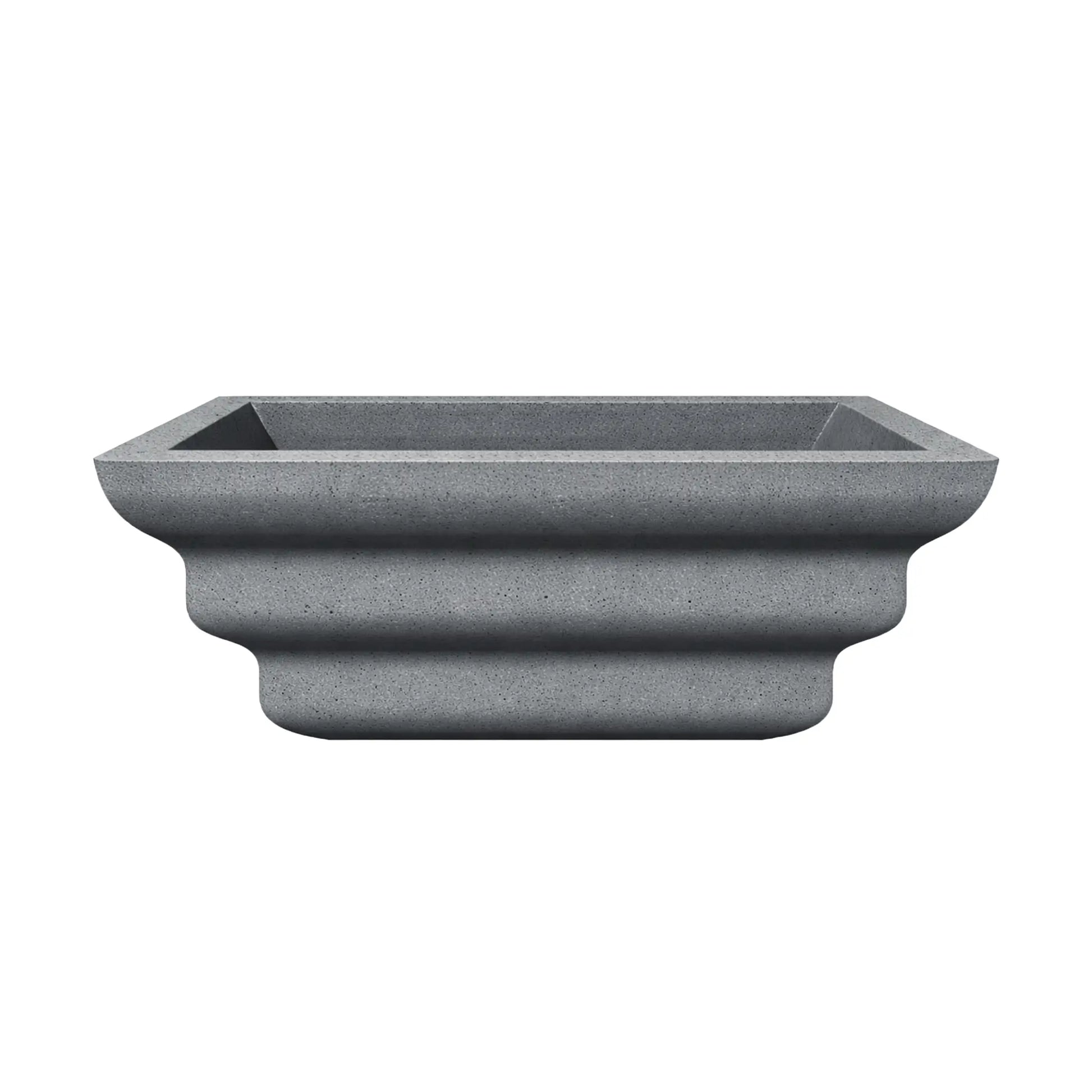 Side profile of the gray Shadow Cast Ripple Designer Series fire bowl with no burner or media installed. The sculpted ripple-style exterior creates three layered curves along the base, giving the bowl a distinctive architectural look. The square top opening and textured gray finish emphasize its modern outdoor fire feature design.