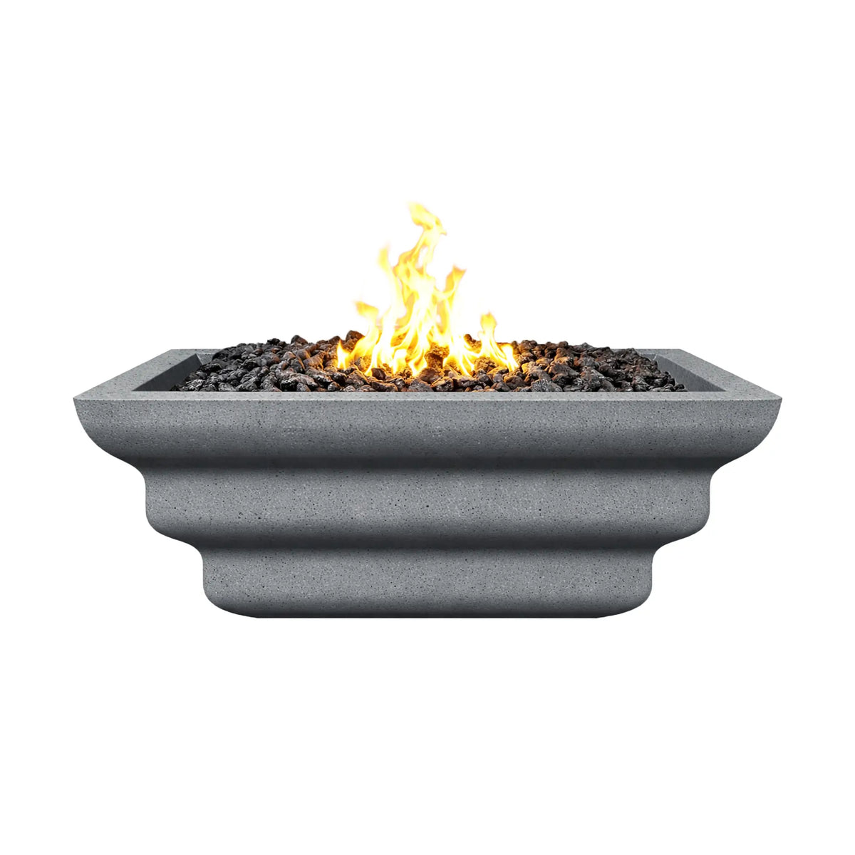 Side view of the gray Shadow Cast Ripple Designer Series fire bowl burning with a bright yellow gas flame above black lava rock media. The bowl’s ripple-style sculpted sides and square rim are visible, while the textured gray concrete-like finish gives the fire feature a modern architectural appearance suitable for outdoor patios and landscape installations.