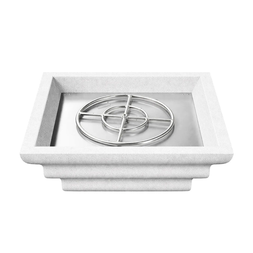 Overhead view of the white Shadow Cast Ripple Designer Series square fire bowl filled with black lava rock media but without flame. The decorative lava rock conceals the gas burner system beneath while the thick square rim and textured white finish showcase the bowl’s contemporary outdoor fire feature design.