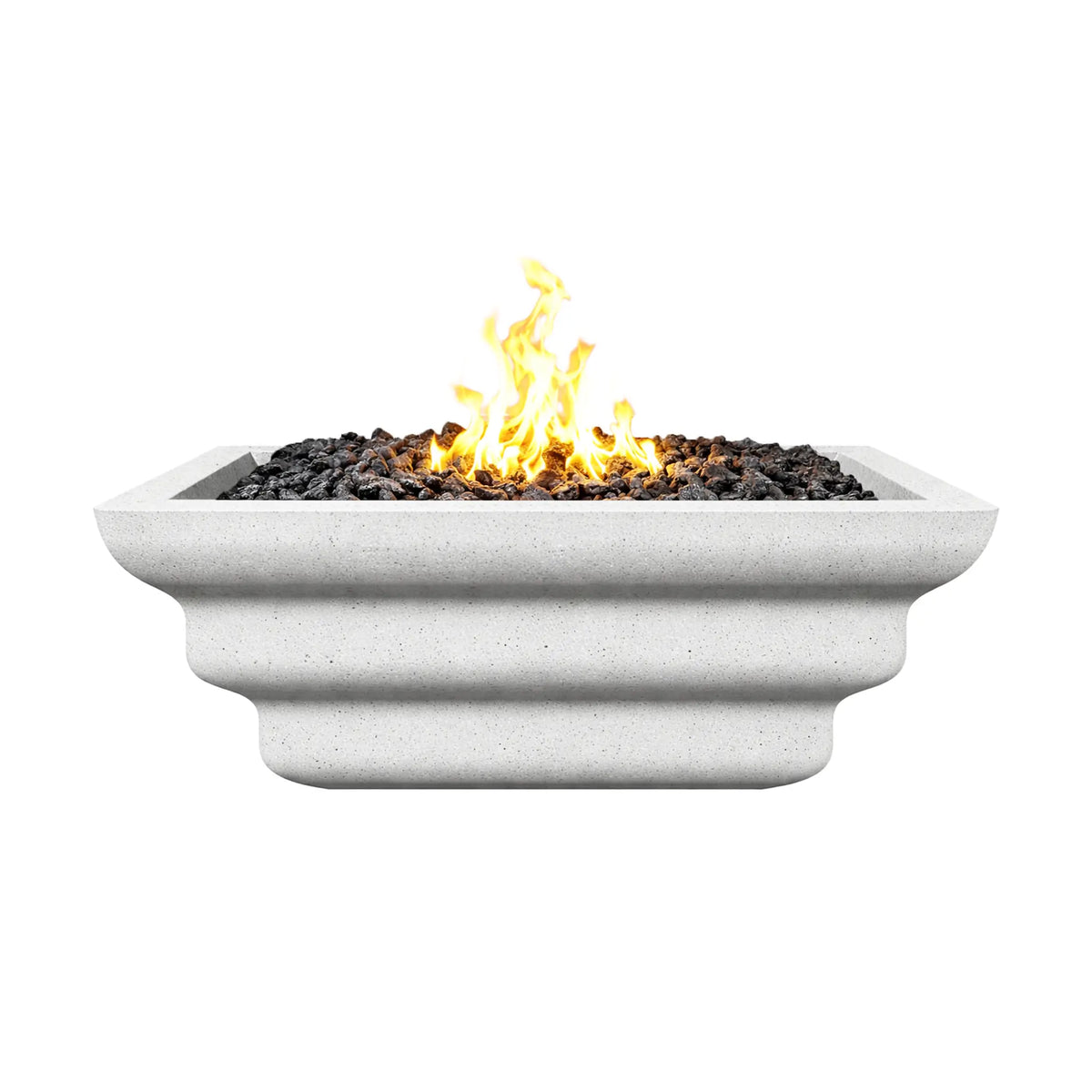 Side elevation view of the white Shadow Cast Ripple Designer Series fire bowl burning with a bright gas flame above black lava rock media. The layered ripple sculpting along the sides and textured white finish create a clean modern look, making the bowl a striking outdoor fire feature for patios, decks, and poolside landscapes.