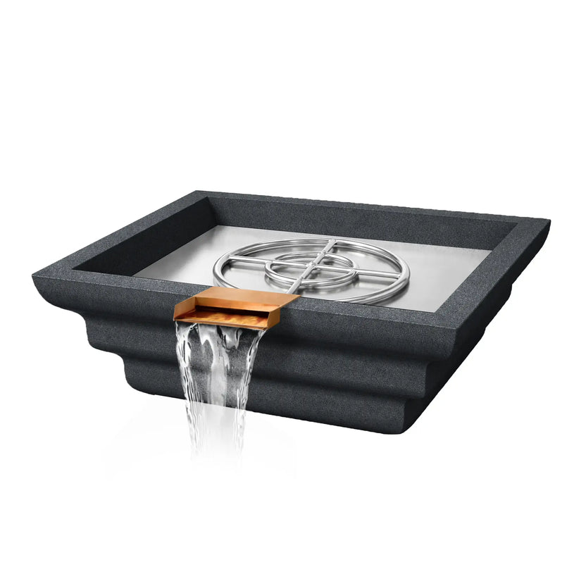 Angled view of the graphite Shadow Cast Ripple Designer Series fire and water bowl with the burner system visible but no flame active. The stainless steel burner ring sits inside a smooth metal burner pan while water flows from the copper spillway at the front. The textured GFRC concrete body features a distinctive stepped ripple pattern.