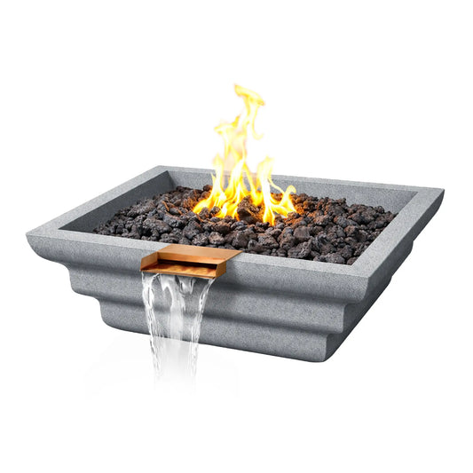 Angled product view of the gray Shadow Cast Ripple Designer Series fire and water bowl by Flame Havens. A lively gas flame burns above dark lava rock media while water flows from a copper waterfall spillway. The light gray GFRC concrete bowl features a modern square shape with layered ripple detailing along the exterior.