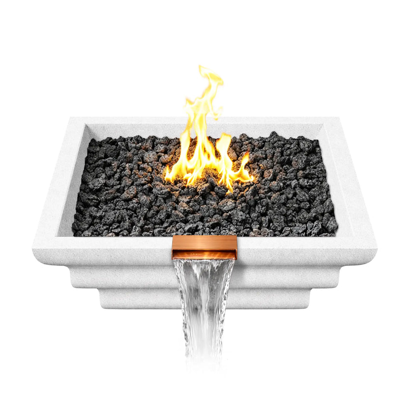 Top view of a white Shadow Cast Ripple Designer Series fire and water bowl filled with black lava rock fire media and an active gas flame at the center. Water flows from the copper spillway at the front edge of the square GFRC bowl, combining a decorative waterfall with a central fire feature.