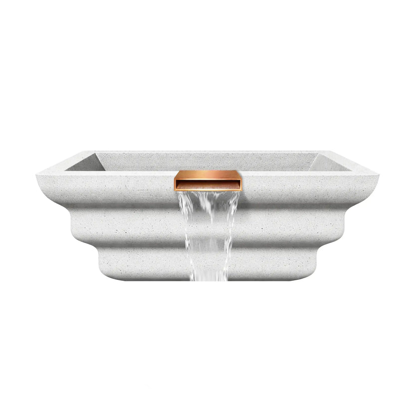 Side profile view of the white Shadow Cast Ripple Designer Series fire and water bowl constructed from textured GFRC concrete. The sculpted ripple-style exterior forms layered curves along the bowl’s sides, while a copper spillway at the center front pours a steady waterfall. The basin is empty, showcasing the architectural form and integrated spillway design used for poolside water features.